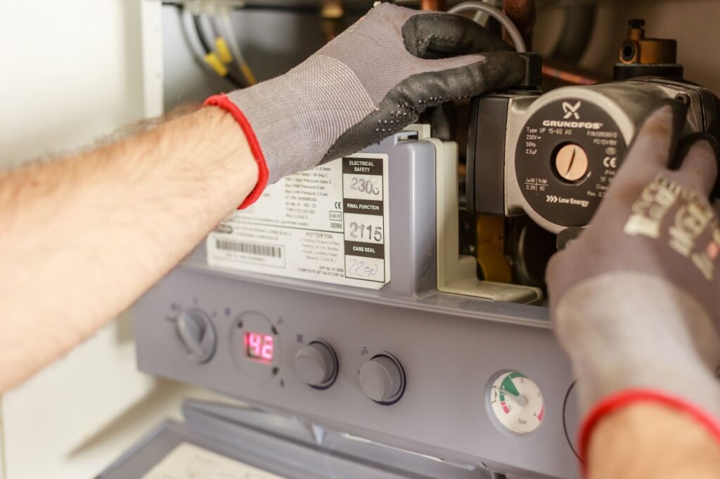 Hands adjusting the controls on a home heating unit during installation