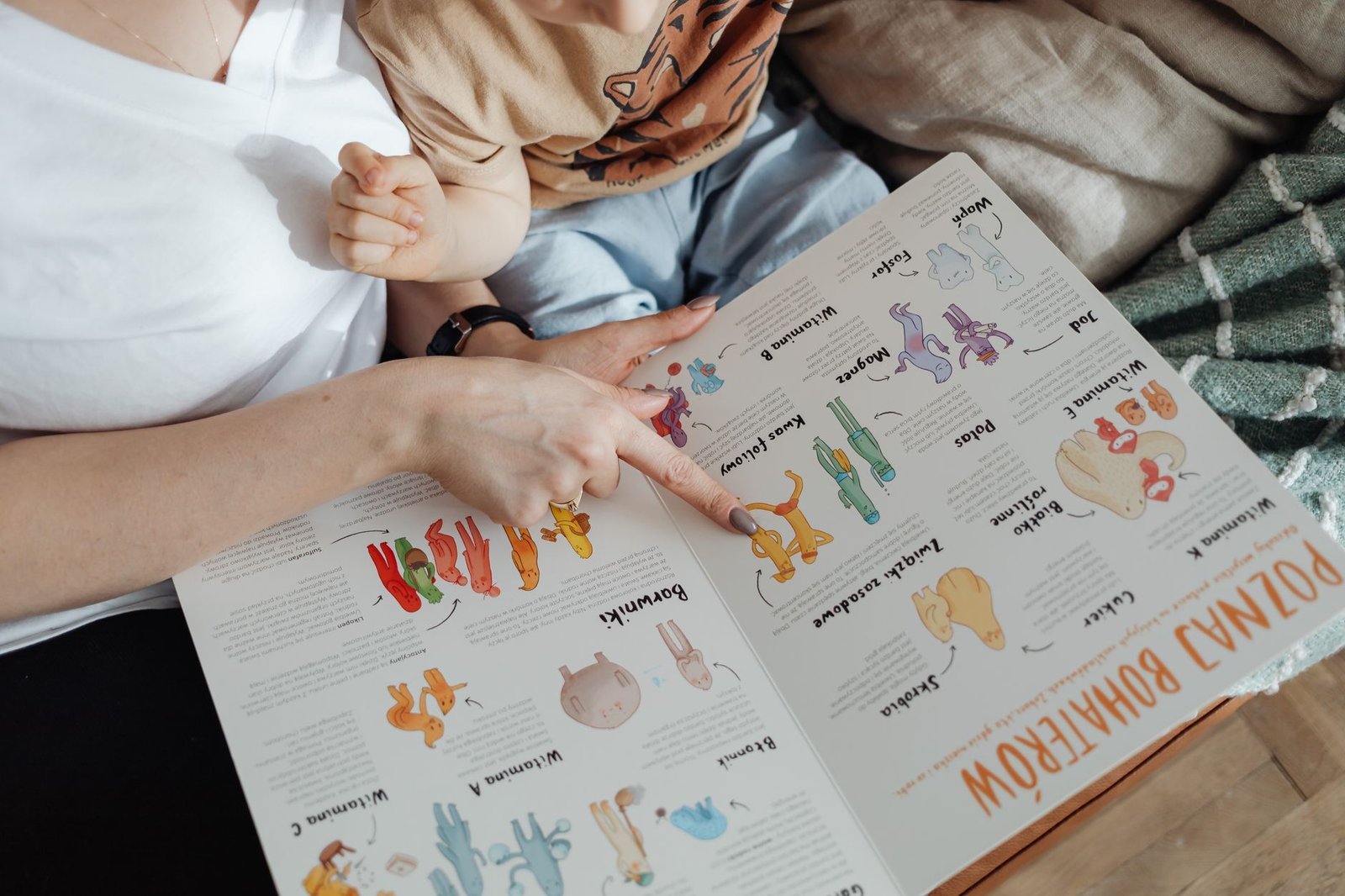 A mother reads a colorful picture book with her young child