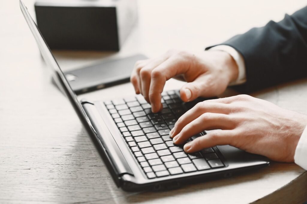 Close-up of hands typing on a laptop keyboard