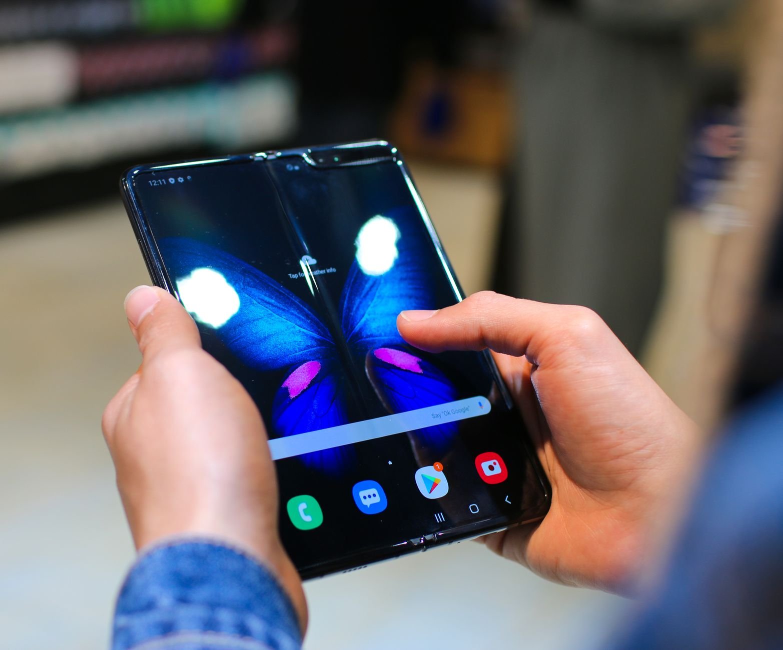 Hands holding a foldable smartphone open, the format the iPhone Fold is reported to use