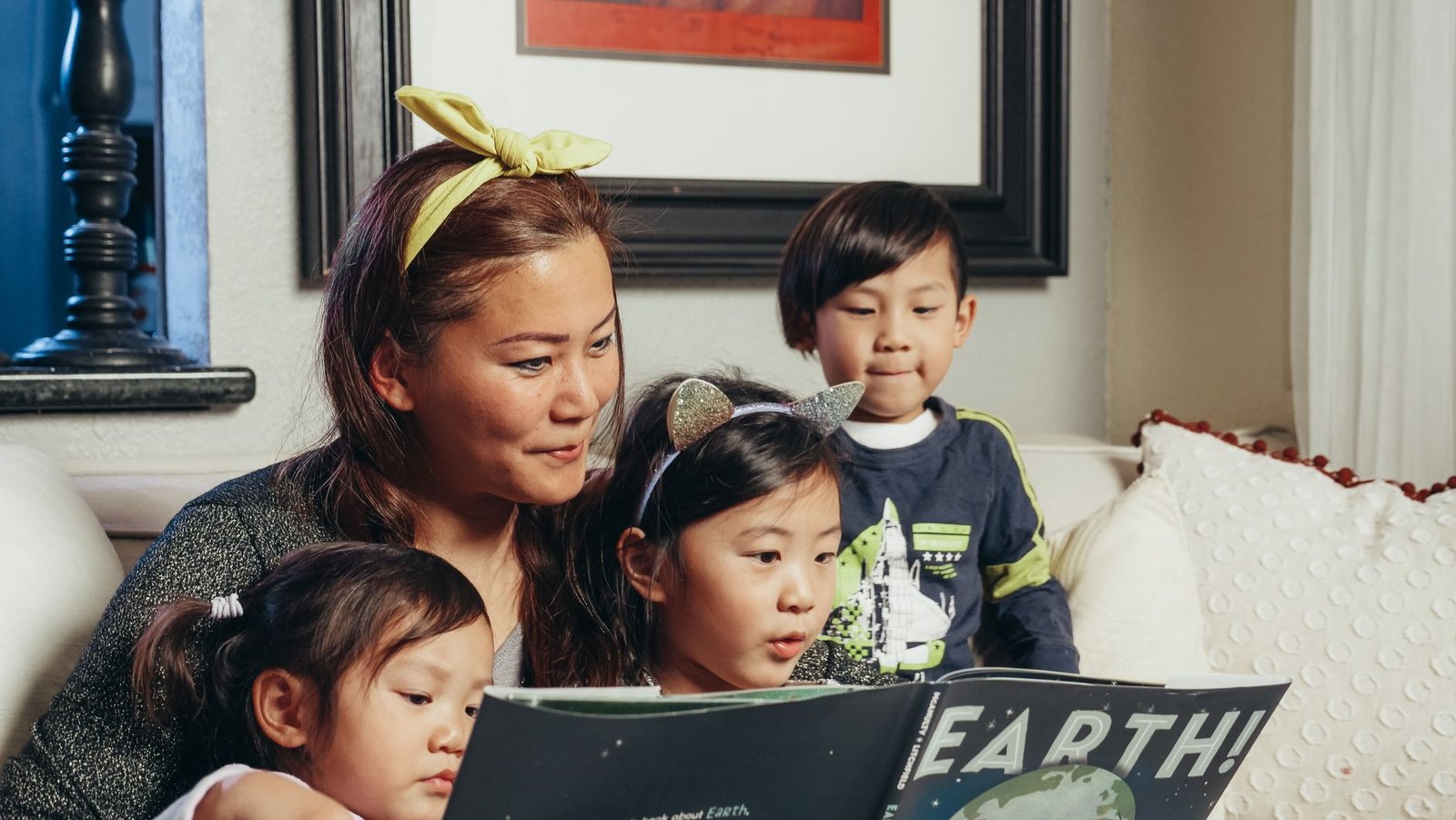 A parent reading aloud to young children who meet Imagination Library eligibility